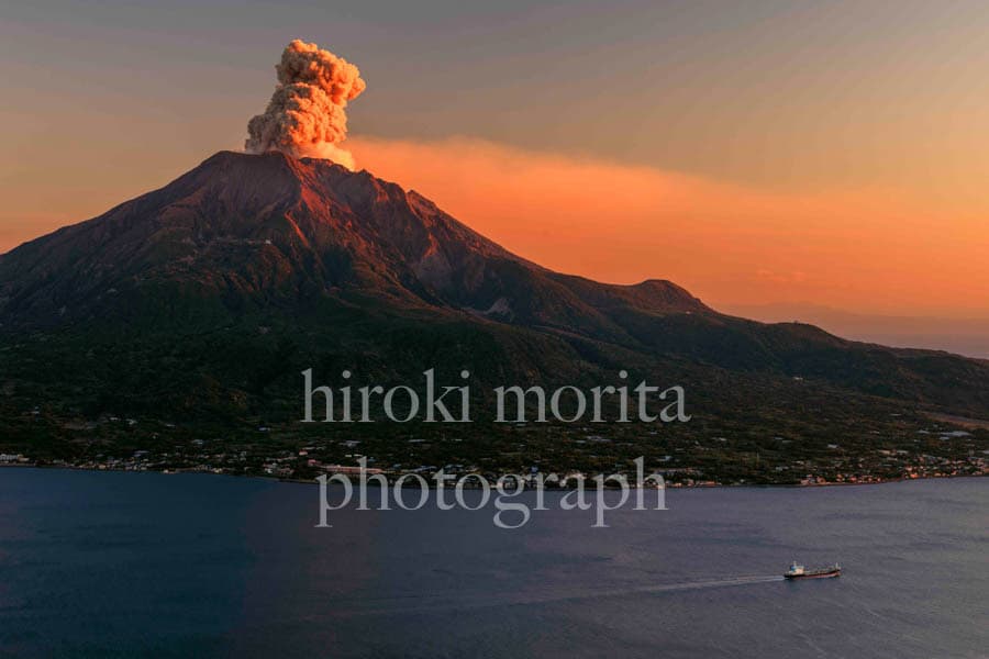 鹿児島県　桜島の噴煙　夕暮れの船とともに　錦江湾
